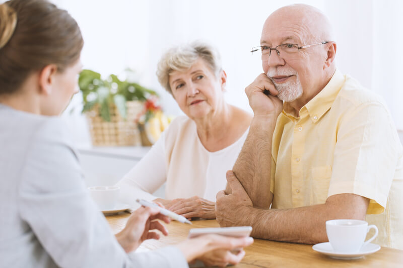 Senior couple at meeting. Senior couple at a meeting with an insurance agent listening to her offer