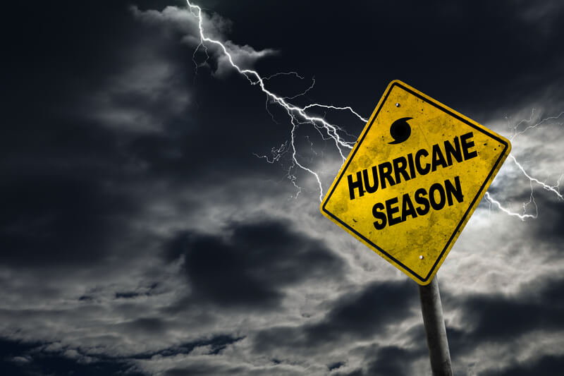 Hurricane Season Sign With Stormy Background. Hurricane season with symbol sign against a stormy background and copy space. Dirty and angled sign adds to the drama.