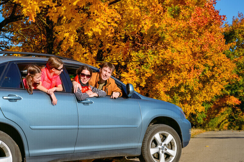 Family travel in car on autumn vacation, happy parents and kids have fun in trip, insurance concept